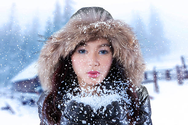istock Beautiful woman blowing snow 614345792