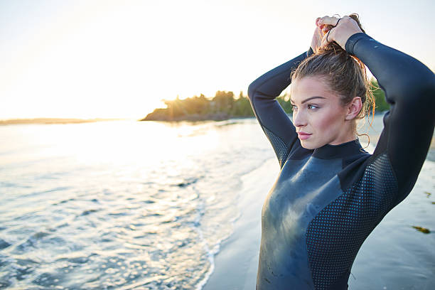 istock Strong beautiful young woman with surf on the beach 614346882