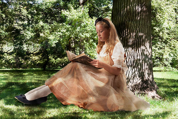 Happy child girl 5-6 year old holding books outdoors over nature background. Back to school.