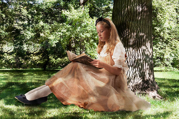 menina lendo livro antigo - little girls alice in wonderland child fairy tale - fotografias e filmes do acervo