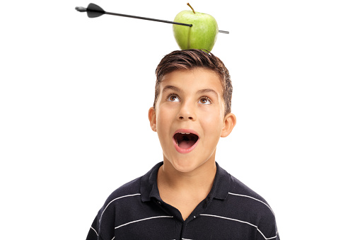 Overjoyed little boy looking at an apple pierced by an arrow on his head isolated on white background