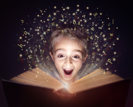 Child reading a magicical story  book with letters leaping off the page
