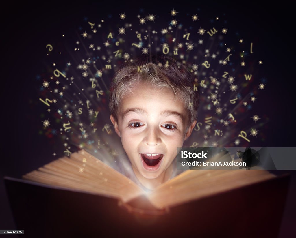Child reading a magic story book Child reading a magicical story  book with letters leaping off the page Child Stock Photo