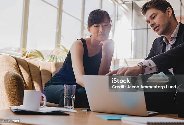 Geschäftspartner Arbeiten Gemeinsam Am Laptop Im Büro Stockfoto und mehr Bilder von Geschäftsbesprechung