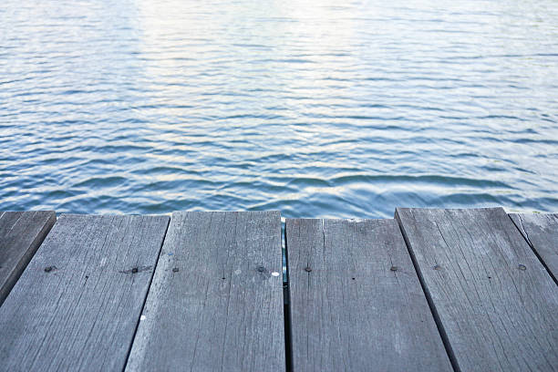 istock Close up wooden pathway for sitting along riverside 614403642