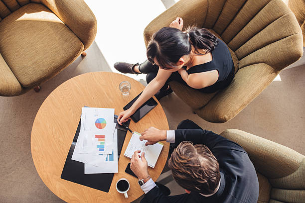 istock Partners discussing new project in office lobby 614404466