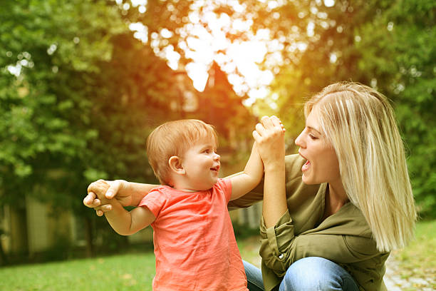 niña con madre al aire libre. - little girls small blond hair child fotografías e imágenes de stock