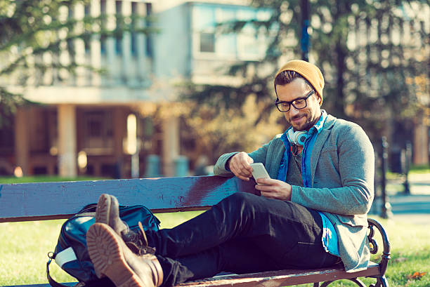 istock enjoying the break sitting on the bench in the park 614408456