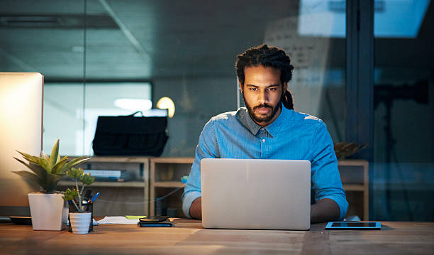To stay productive you need to stay persistent Cropped shot of a young designer working late on a laptop in an office dedication photos stock pictures, royalty-free photos & images