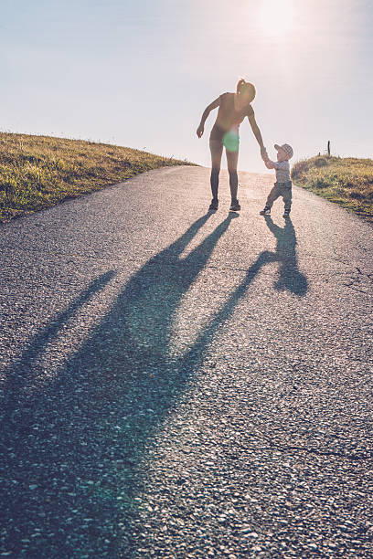istock Baby walking with help of its parents - first steps 614411302