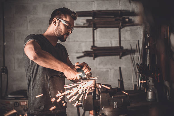 Man at work. Confident young man grinding with sparks in repair shop steel grinding stock pictures, royalty-free photos & images