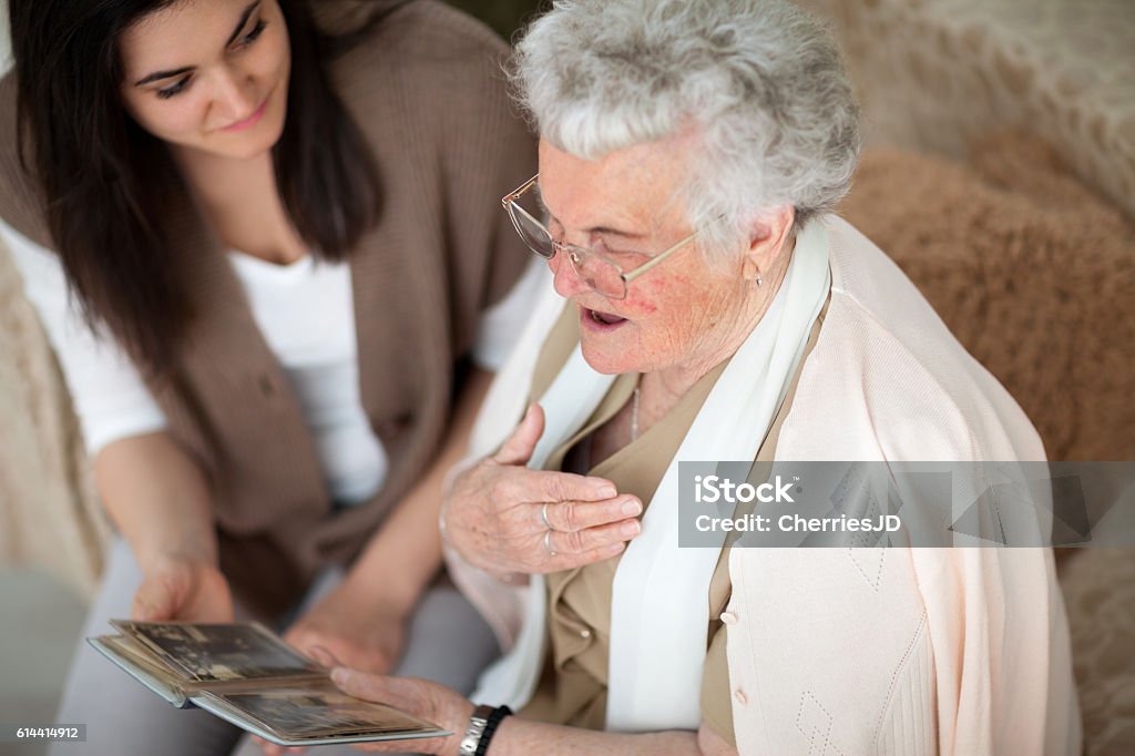 Stories from grandma's past Grandma showing old photo album to her granddaughter Memories Stock Photo