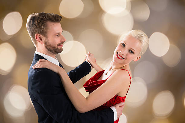 pareja joven bailando en bokeh fondo - waltz fotografías e imágenes de stock