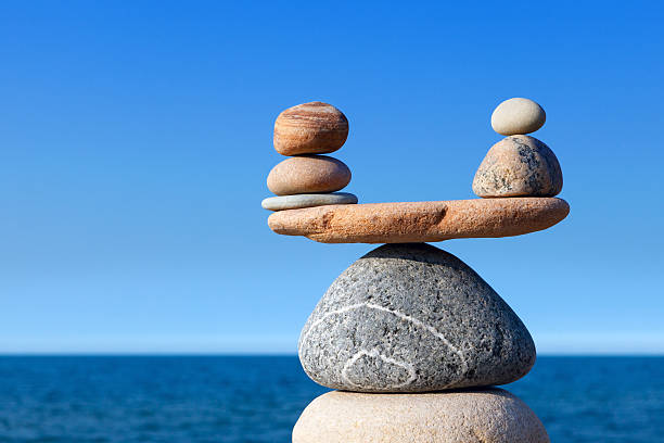 concetto di armonia ed equilibrio. equilibrio pietre contro mare. - perfection nature balance stone foto e immagini stock