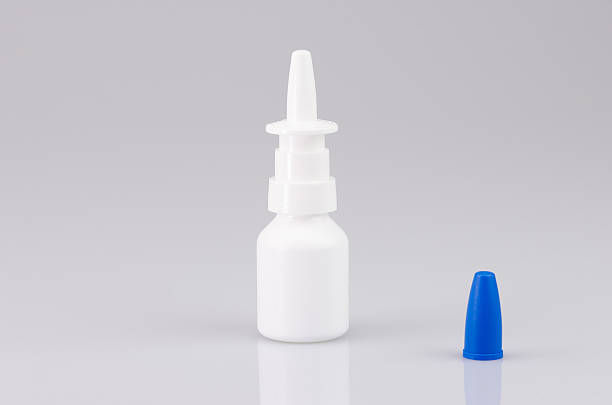 istock White nasal spray on a light gray reflecting background 614419994