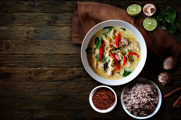 pollo verde al curry sobre mesa de madera. cocina tailandesa - guindilla fotos fotografías e imágenes de stock