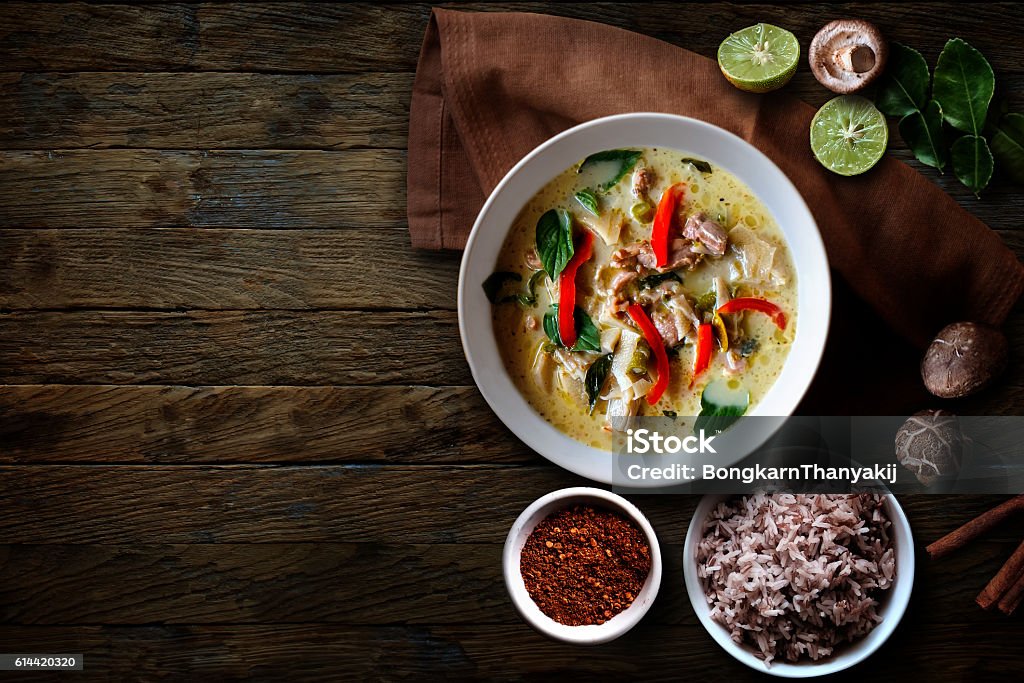 Green Chicken Curry over wooden table.Thai cuisine Food Stock Photo