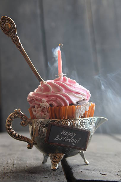 Chocolate birthday cake with lighted candles on the table