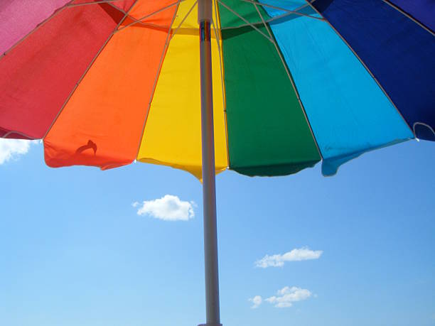 istock Rainbow colorful beach umbrella in summertime 614421364