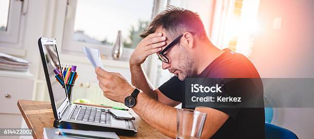 Man Reading Letter And Felling Worried Stock Photo - Download Image Now - Financial Bill, Emotional Stress, Physical Pressure