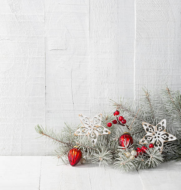 istock Fir branch with Christmas decorations on white rustic wooden background. 614422012