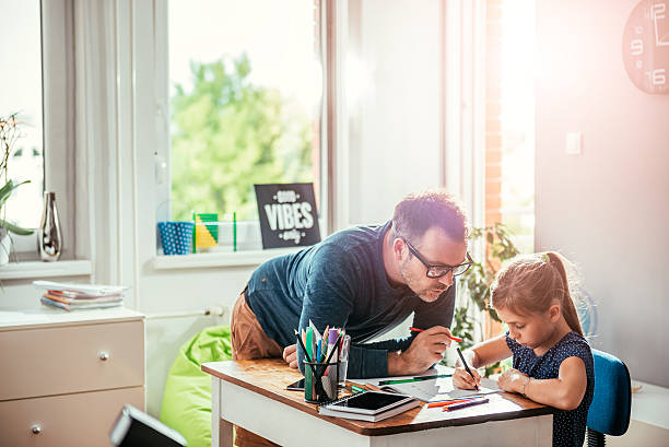 father helping daughter to finish homework - homework imagens e fotografias de stock