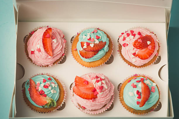 istock Closeup of six decorated cupcakes in paper gift box 614426730