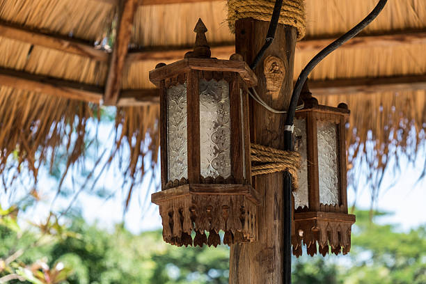 istock Two lantern tied with rope to the wooden pole. 614428104