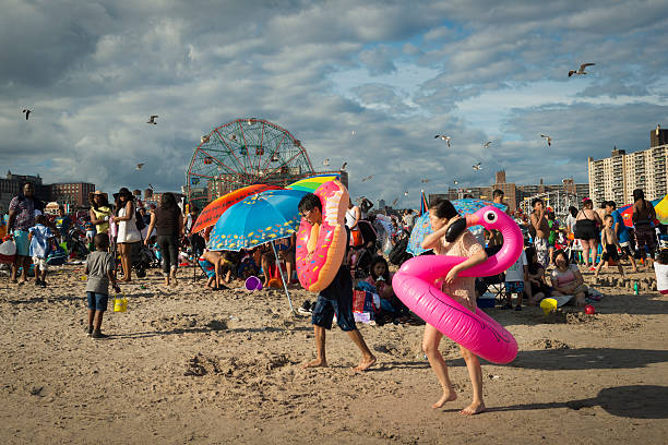 Coney Island, NY, USA - July 10, 2016: People enjoy a crowded summer day at the beach at Coney Island in New York