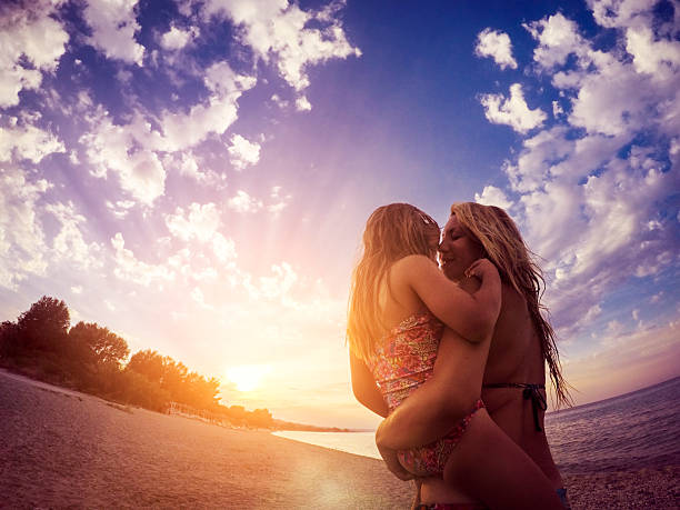 istock Mother and daughter hugging on the beach at sunset 614429570
