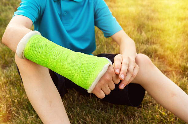 young boy with broken arm Young boy making with a broken arm in a cast orthopedic cast stock pictures, royalty-free photos & images