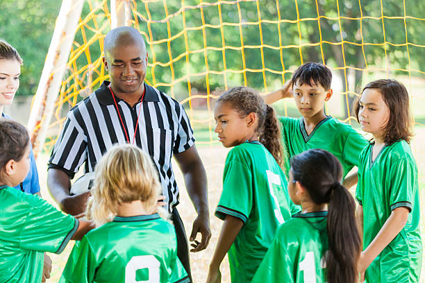 árbitro de fútbol explica reglas al equipo - soccer child coach childhood fotografías e imágenes de stock