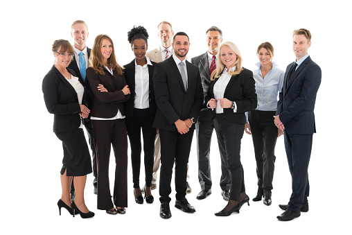 Cheerful mixed race office workers standing outdoors in a business district. They are holding a digital tablet and a notebook. They are wearing formal clothing.