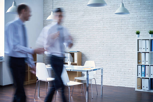 Blurred motion in office Defocused managers going and talking in the office defocused office business motion stock pictures, royalty-free photos & images
