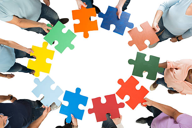 istock Creative Business Team Holding Colorful Jigsaw Pieces 614431052