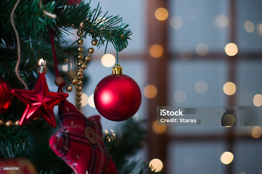 Shiny Christmas red ball hanging on pine branches Shiny Christmas red ball hanging on pine branches with festive background Christmas Ornament Stock Photo