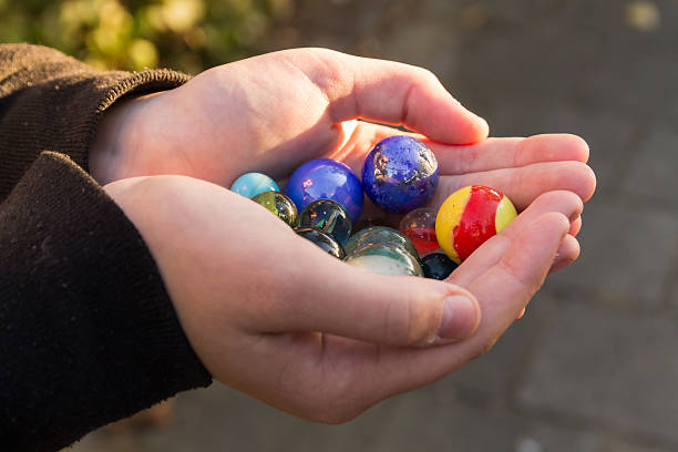 istock Marbles in the hands of a child. 614433318