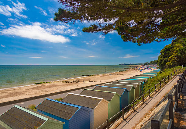Beach Huts at Solent Beach, Hengistbury Head, Bournemouth, Dorset, England Blue and green beach uts line the promenade overlooking Solent Beach near Hengistbury Head and Mudeford Quay, Christchurch and Bournemouth in Dorset bournemouth england photos stock pictures, royalty-free photos & images