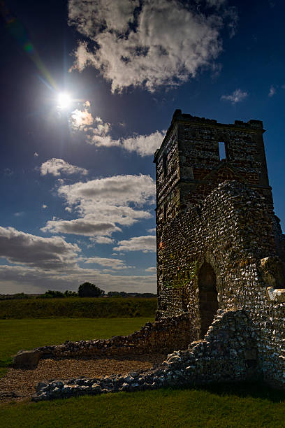 Late summer sunshine on the medieval Knowlton Church, Wimborne, Dorset The sun shines on the flint stone church ruins at Knowlton in Dorset. The lush green grass contrasts with the deep blue sky knowlton stock pictures, royalty-free photos & images