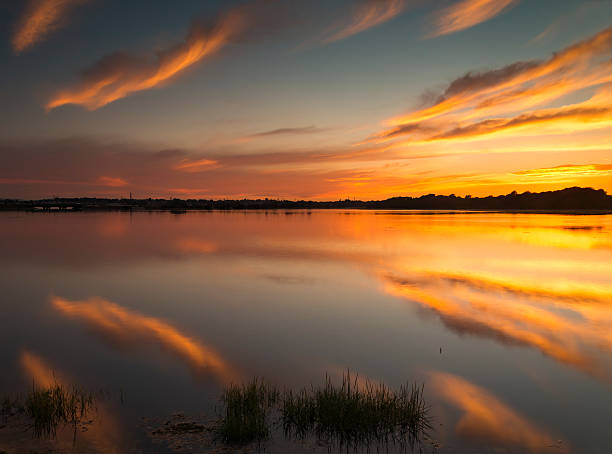 istock Sunset colours illuminate clouds reflected perfectly in Poole Harbour 614434134