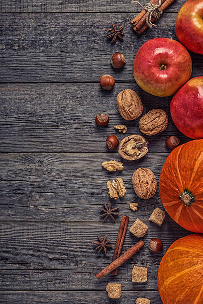 istock Wooden background with pumpkin, apples, nuts and spices. 614434794