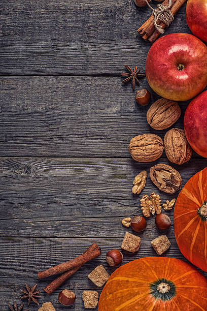 istock Wooden background with pumpkin, apples, nuts and spices. 614434958