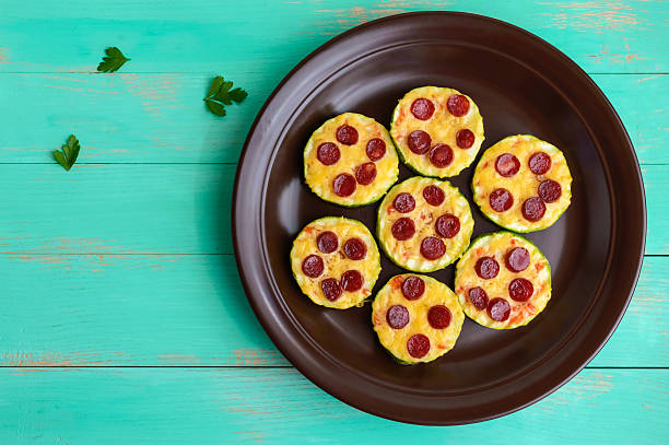 small zucchini pizza on the circles with pepperoni and mozzarella. - pepperoni pizza green olive italian cuisine tomato sauce imagens e fotografias de stock