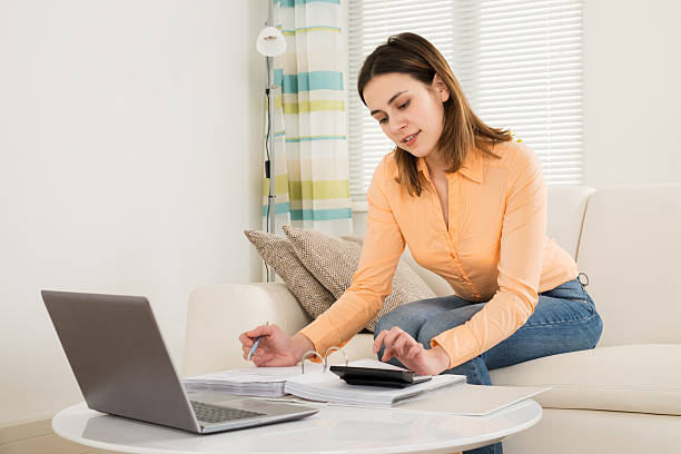 istock Woman Calculating Bills In Her Room 614435836