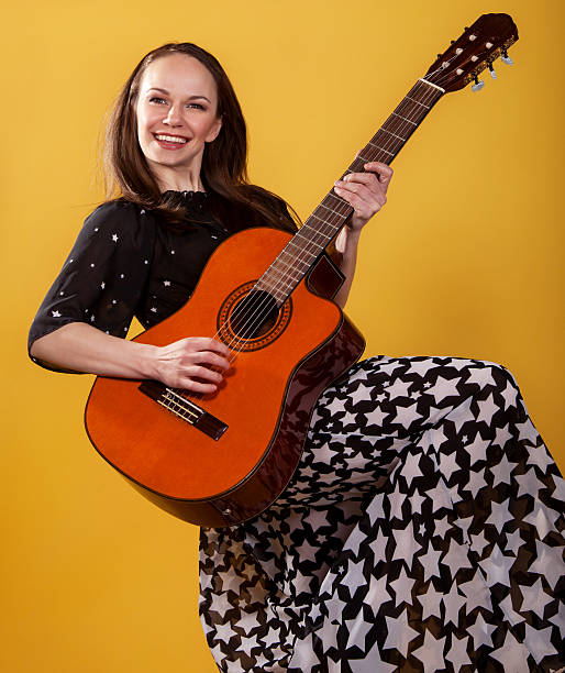 istock Brunette guitar player woman 614436126