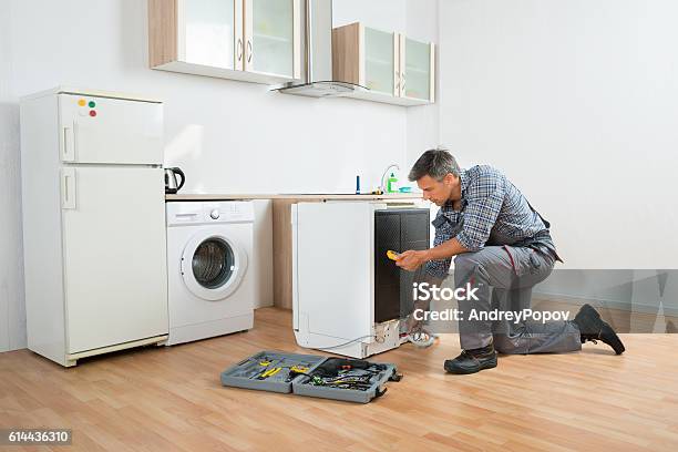 Technician Checking Dishwasher With Digital Multimeter Stock Photo - Download Image Now