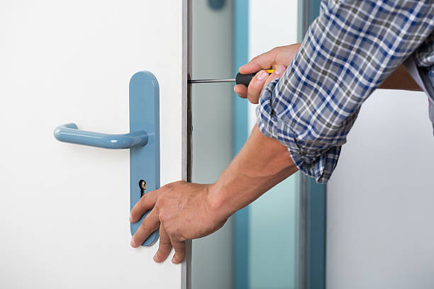 istock Technician Fixing Lock In Door With Screwdriver 614436594