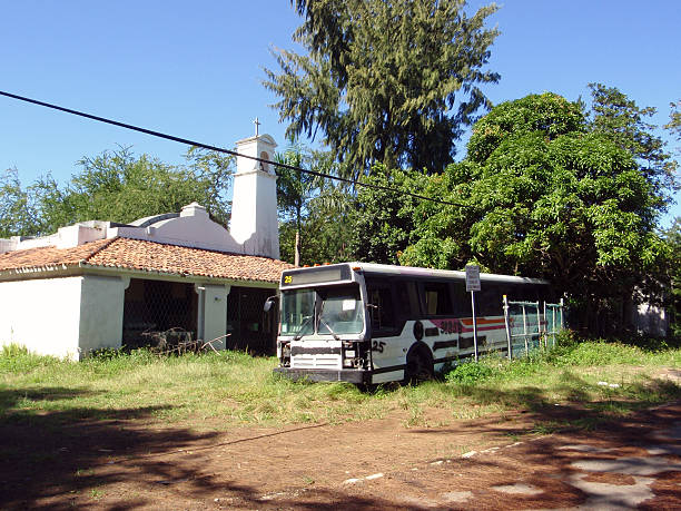 istock Broken down bus rests next to a rundown chapel 614438360
