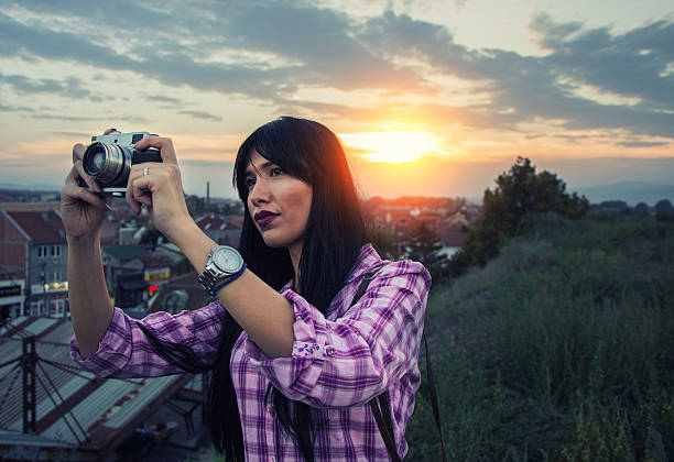 istock girl, retro camera and the beautiful sunset sky 614439576