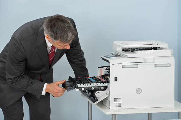 istock Businessman Fixing Cartridge In Printer Machine At Office 614439664